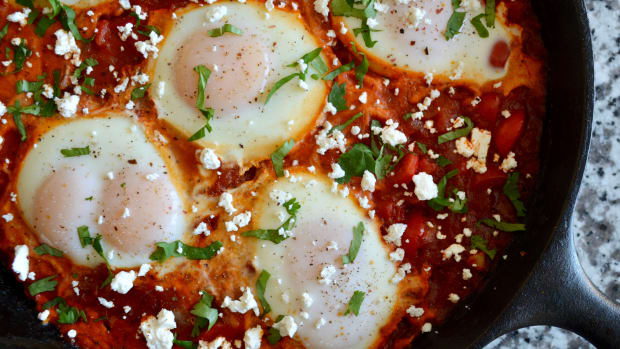Shakshuka recipe, poached eggs in tomato sauce in a cast iron pan