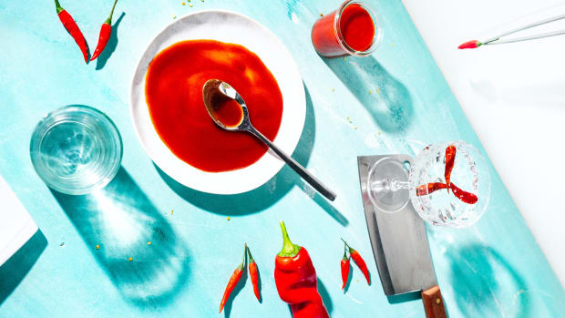 hot peppers on table with knife and glass of water for a 5 ingredient hot sauce recipe