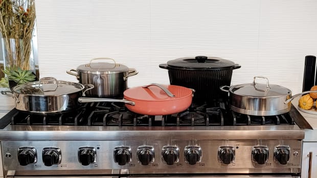 Image of 5 different pots and pans on top of a 8 burner viking stove that belongs to Laura Klein. All of the cookware featured is part of the best non-toxic cookware you can find on the market today. Stovetop brands include caraway cookware, GreenPan, Alva Cookware, Xtrema and Demeyere.
