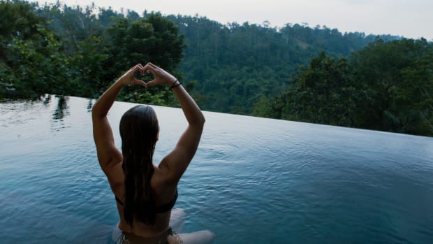 5 ways to biohack your health for improved overall wellness. Woman in pool overlooking forest.