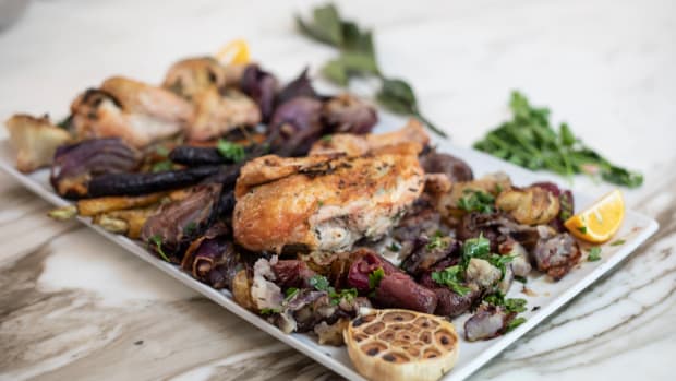 roasted sheet pan chicken with rainbow carrots and potatoes on a platter.