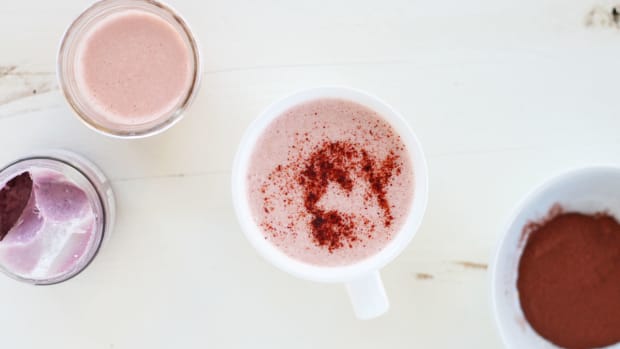 a pretty pink beetroot latte in a white cup sprinkled with beetroot powder