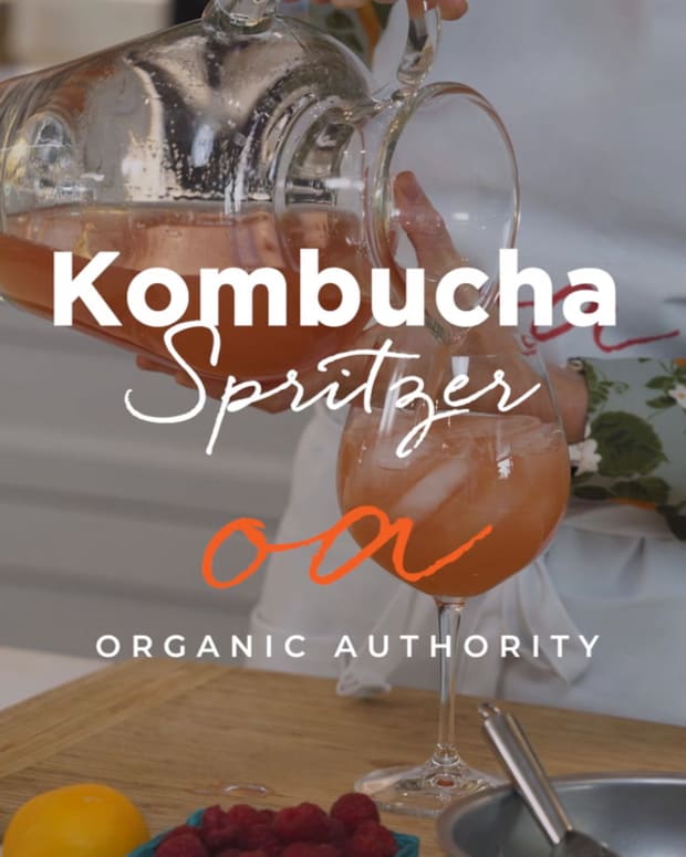 Woman pouring pitcher of kombucha spritzers into wine glass.