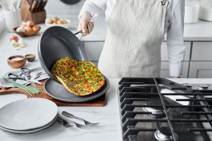 Person sliding frittata onto a plate out of a nonstick GreenPan.