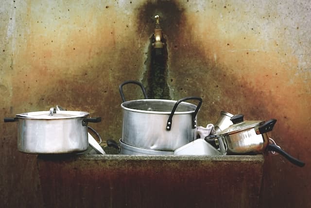 aluminum cookware pots and pans in a pile.