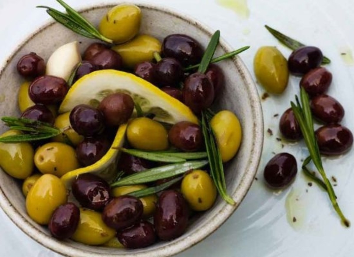 Marinated olives, rosemary and lemon in a small bowl.