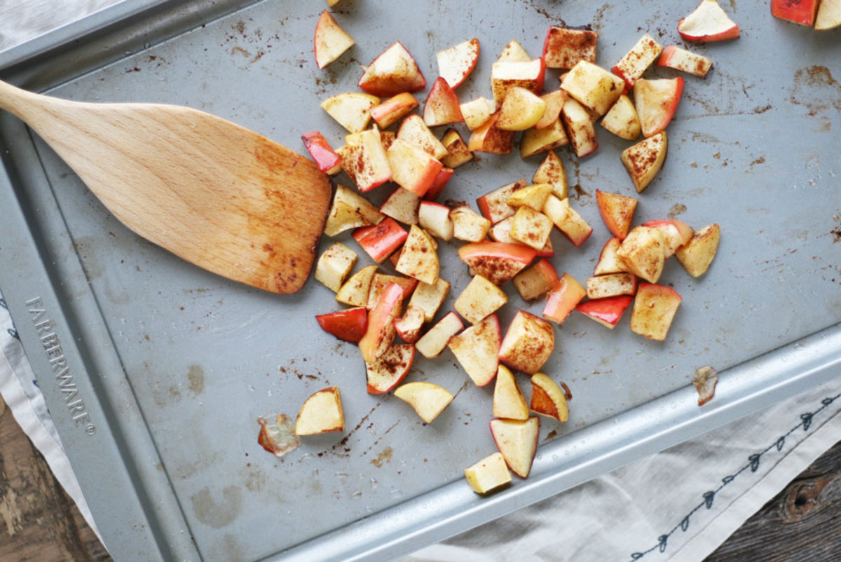 apple chunks tossed with cinnamon on a baking tray