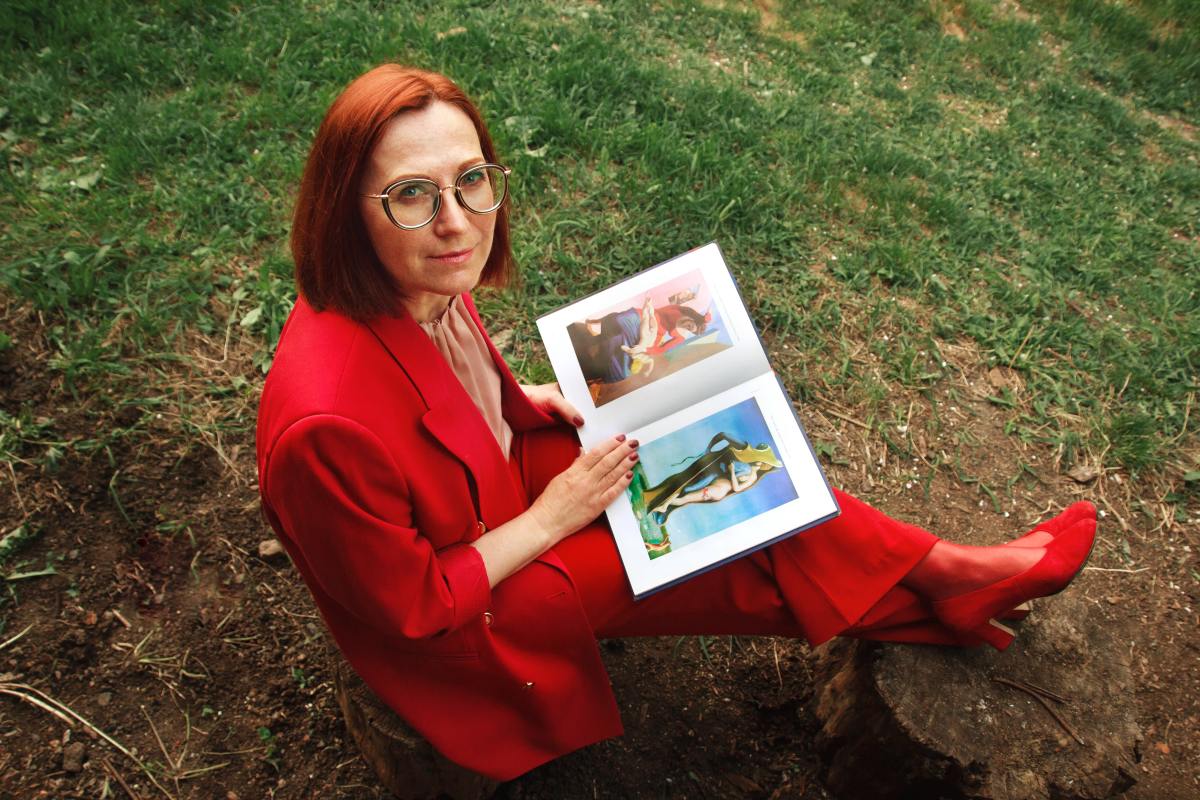 Woman in vibrant red suit reads outside, practicing self-care, a vital component for natural remedies for menopause.