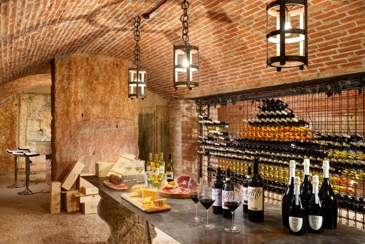 Wine cellar tasting room with brick arches, wine bottles, charcuterie board, and glasses.
