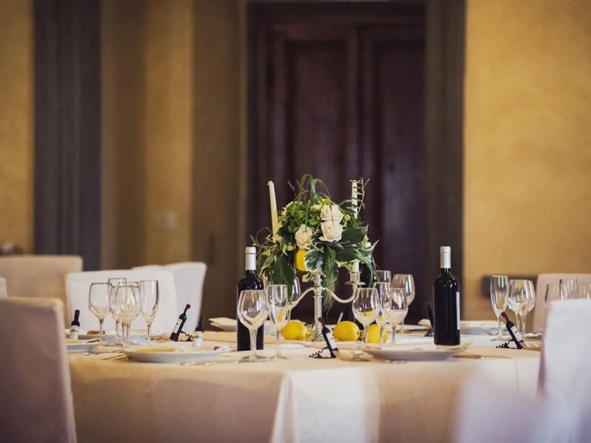Elegant dining table set with wine bottles, glasses, and floral centerpiece in a luxury hotel