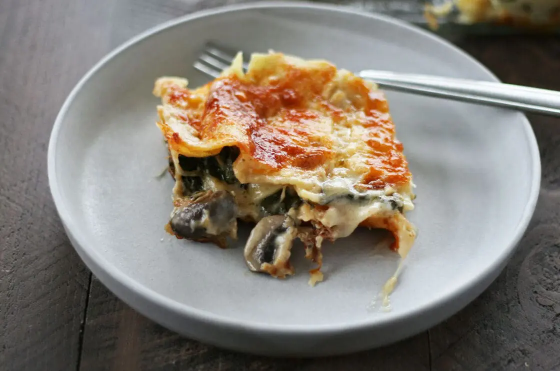 Image of a slice of vegetarian lasagna on a grey ceramic plate.