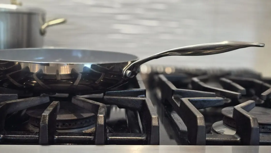 Image of a Valencia Pro frypan with mirror finish on a gas stovetop.
