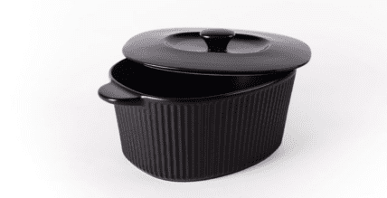 Image of the best Dutch oven according to our chef, this Dutch oven is made of ceramic and is oval and black with scalloped details on the outside, two handles, and a lid with a handle.