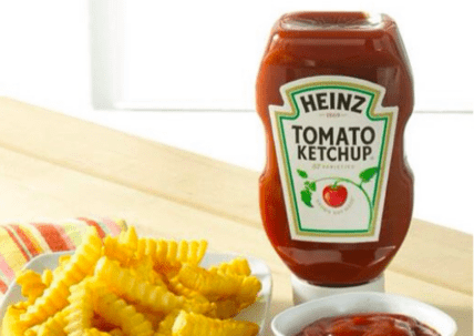 Heinz tomato ketchup bottle next to french fries and a small dish of ketchup
