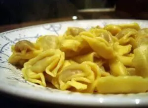 Yellow gluten-free pasta shapes on a decorative white plate
