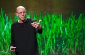 Michael Pollan speaking in front of a green data visualization display