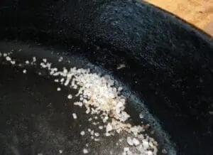 Sea salt crystals on a seasoned cast-iron skillet surface