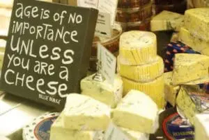 Various aged cheeses displayed with a sign reading "age is of no importance unless you are a cheese