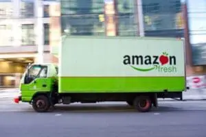 Amazon Fresh delivery truck driving through urban street