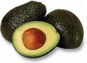 Two whole avocados and one halved avocado showing the pit and pale green flesh