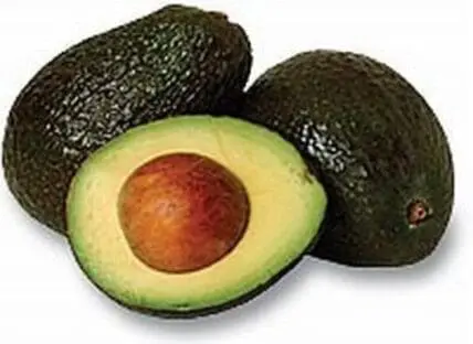 Two whole avocados and one halved avocado showing the pit and pale green flesh