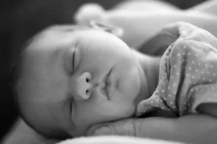 Sleeping newborn infant in black and white photography
