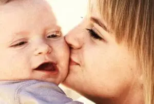 Woman kissing infant on the cheek