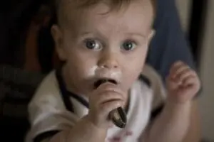 Malnourished infant with hand near mouth