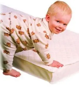 Toddler in teddy bear pajamas crawling on an organic baby mattress