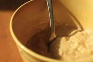Spoon in a bowl of brown paste-like DIY facial mask ingredient