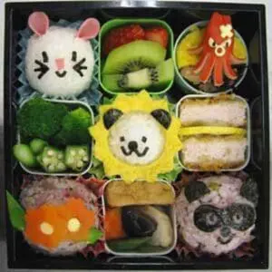 Decorative bento box with animal-shaped food arrangements and fresh vegetables