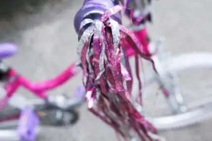 Colorful bike streamers and handlebar decorations on a children's bicycle