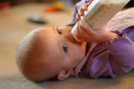 Infant drinking from a bottle