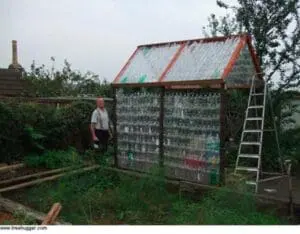 Greenhouse structure built from plastic bottles with metal frame and corrugated roof