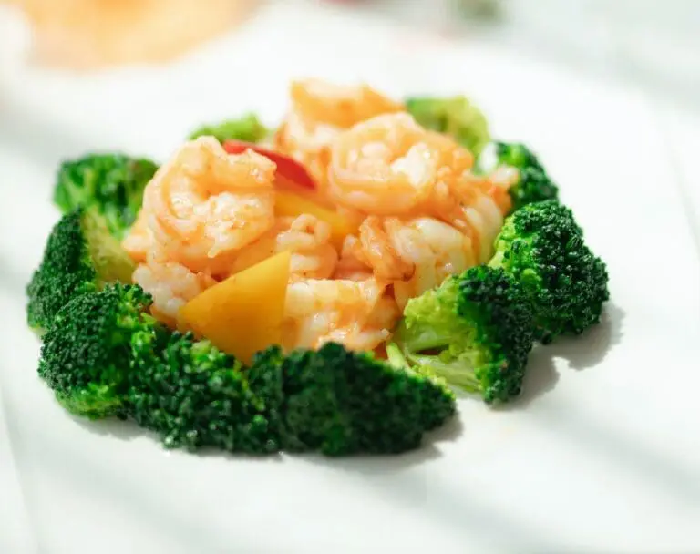 Image of bed of shrimp surrounded by a circle of broccoli, which contains sulforaphane benefits