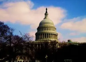 The U.S. Capitol building dome against a blue sky with clouds