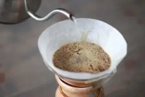 Water being poured over ground coffee in a filter cone