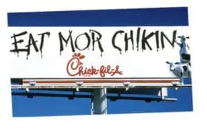 Chick-fil-A billboard with "Eat Mor Chikin" text and cow character