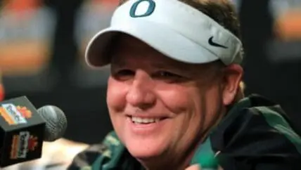 Philadelphia Eagles coach speaking at podium wearing white Nike visor