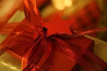 Red ribbon bow on a wrapped gift box with star decoration