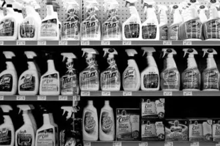 Shelves stocked with various household cleaning products in spray bottles and containers