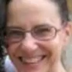 Woman wearing glasses smiling at the camera