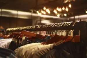 Clothing rack with hangers of garments displayed under warm lighting