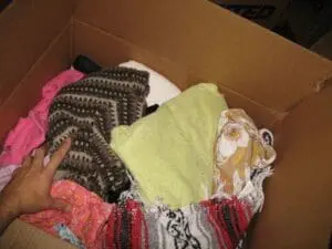 Cardboard box filled with folded clothing and textiles for donation or storage