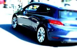 Blue compact car with open door displayed outdoors
