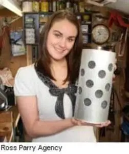 Young woman holding a polka-dotted cylindrical container in a home workspace
