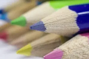 Sharpened colored pencils with blue, green, yellow, and pink tips in close-up