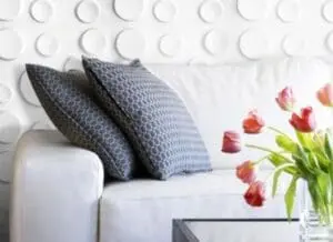 Modern living room with white sofa, blue patterned pillows, and fresh red tulips in vase