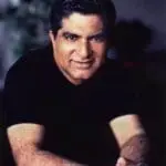 Deepak Chopra smiling at the camera in a black shirt