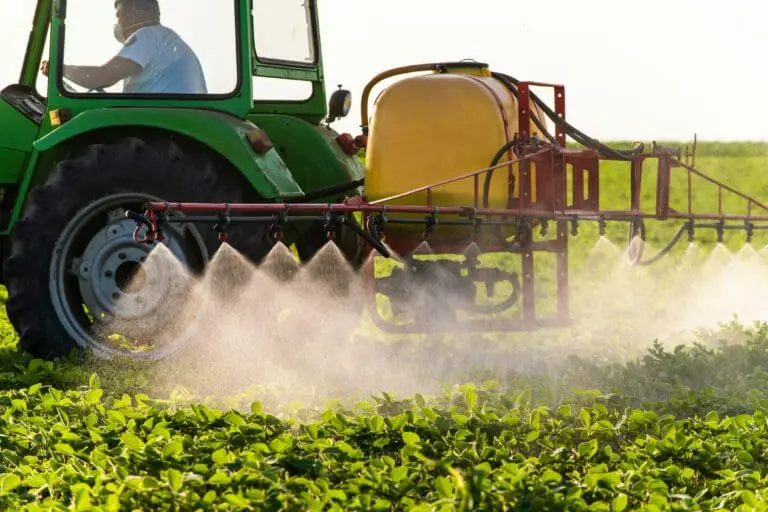 Image of a farmer wearing a mask on a tractor spraying a crop with dangerous endocrine disrupting fungicides according to this year's EWG Dirty Dozen report.